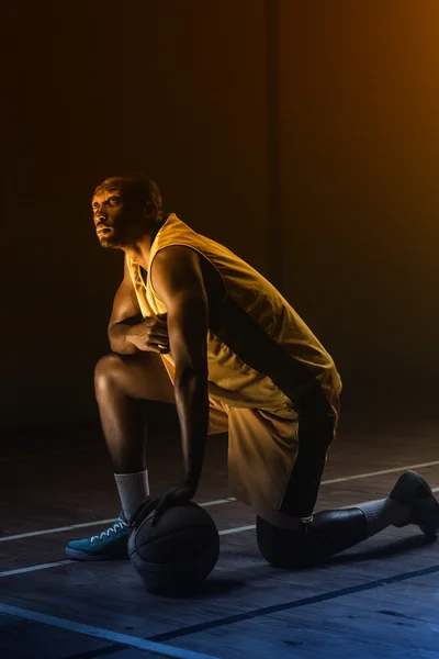 Basketbalspeler met knie op verdieping — Stockfoto