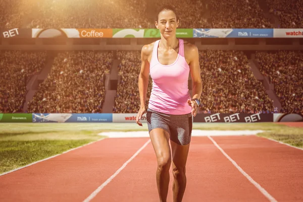 Woman running against  athletic field — Stock Photo, Image