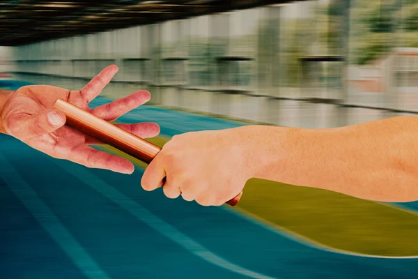 Athlete passing baton to partner — Stock Photo, Image