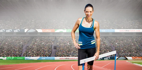 Portswoman posing next to hurdle — Stock Photo, Image