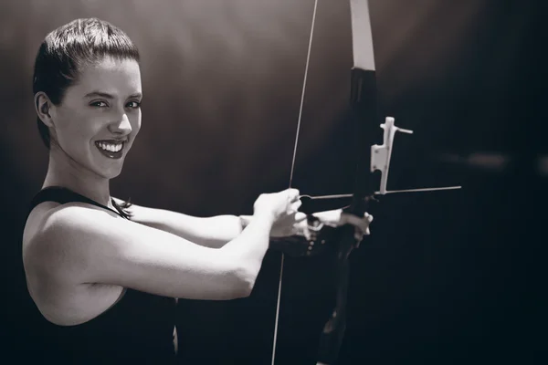 Sportswoman smiling and practising archery — Stock Photo, Image