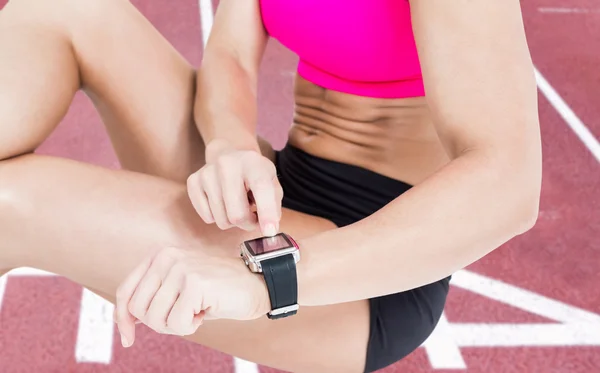 Sportler sitzt und nutzt Smart Watch — Stockfoto