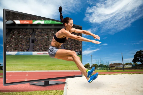 Sportskvinne som hopper mot stadion – stockfoto