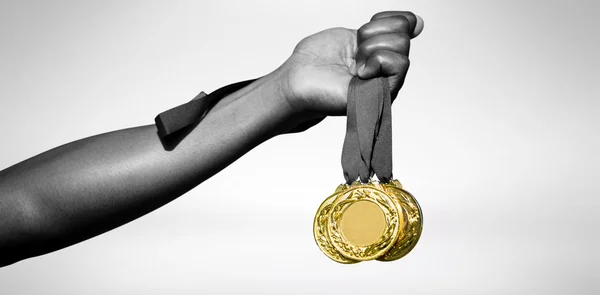 Hand holding three gold medals — Stock Photo, Image