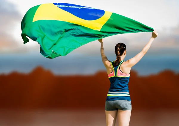 Sportswoman raising brazilian flag — Stock Photo, Image