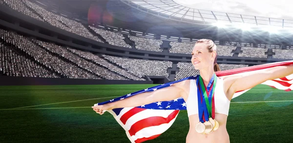 Årets idrottskvinna med medaljer holding amerikanska flaggan — Stockfoto