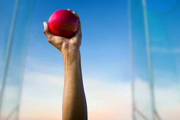 Mão segurando bola vermelha — Fotografia de Stock