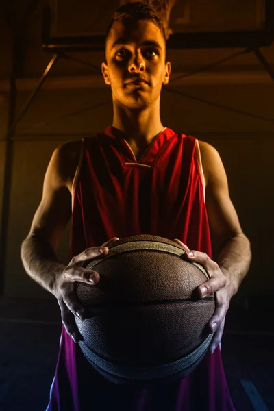 Jogador de basquete sem sorrir e segurando basquete — Fotografia de Stock