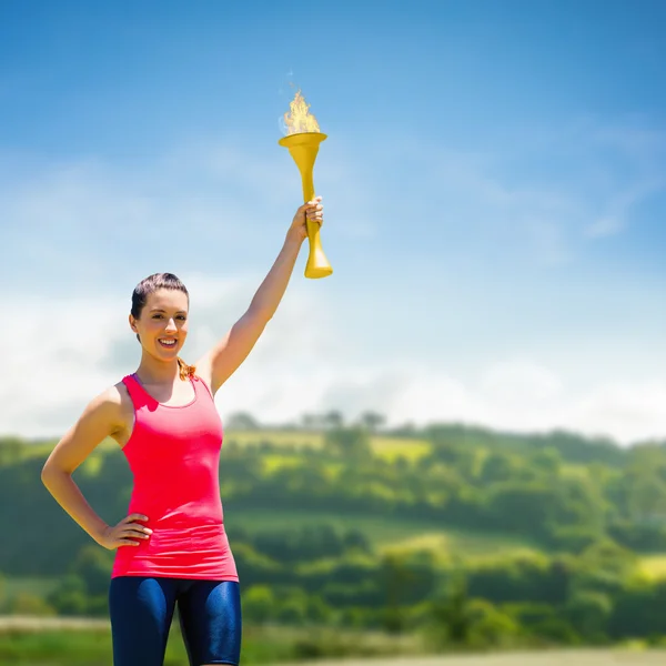 Sportliche Frau posiert mit olympischer Fackel — Stockfoto