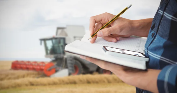 Agricultor escrevendo com lápis no livro — Fotografia de Stock