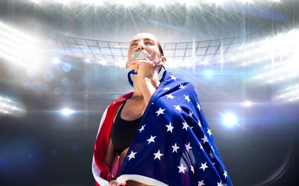 Frau mit amerikanischer Flagge küsst Medaille — Stockfoto