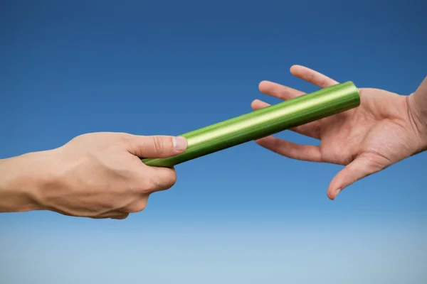 Athlete passing baton to partner — Stock Photo, Image