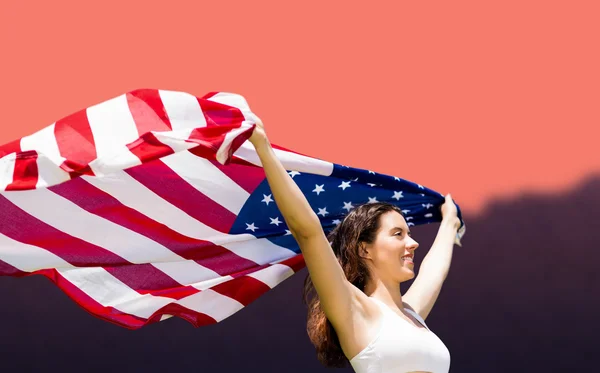 Спортсменка, поднимающая американский флаг — стоковое фото
