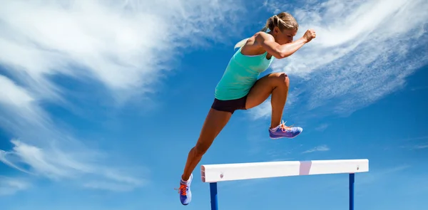 Atlet kvinde hoppe hurdle - Stock-foto