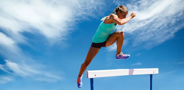 Atleta mujer saltar obstáculo — Foto de Stock