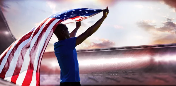 Sportif hissant un drapeau américain — Photo