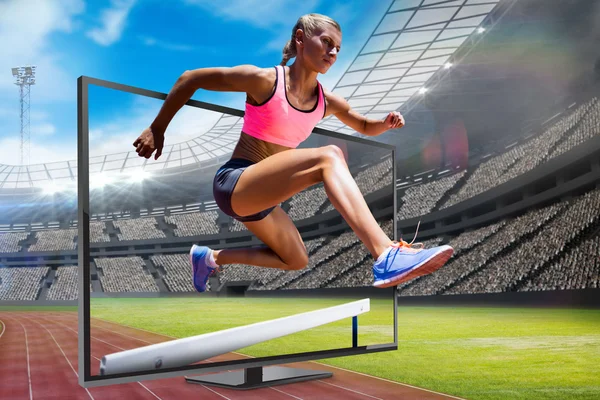 Urheilullinen nainen hyppy este — kuvapankkivalokuva