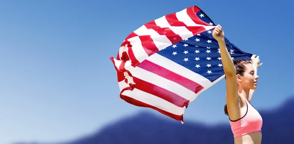 Спортсменка, поднимающая американский флаг — стоковое фото