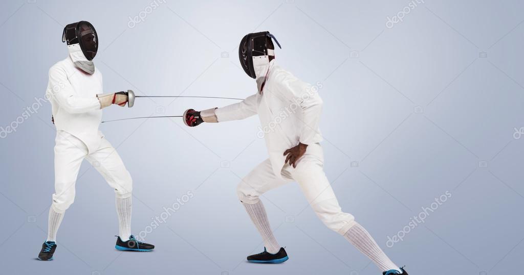 Men in fencing suits practicing with swords Stock Photo by