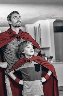 Father and son pretending to be superhero clipart