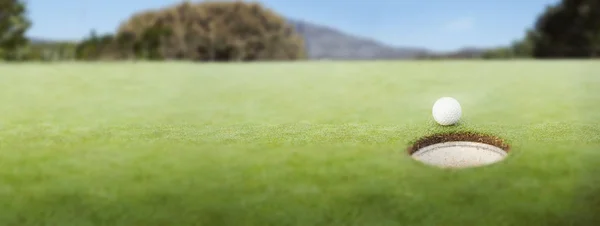 Pelota de golf en el borde del hoyo —  Fotos de Stock