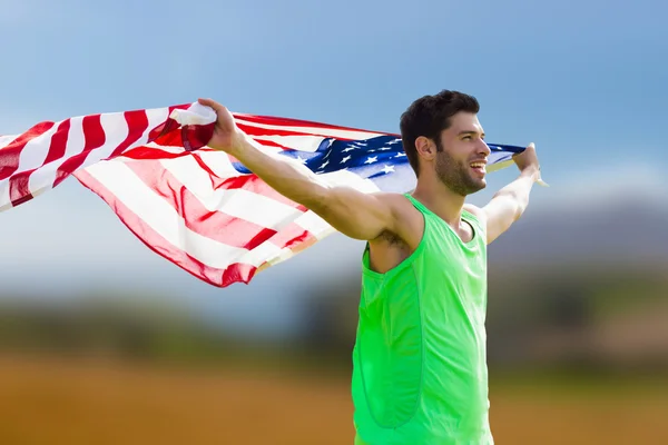Deportista sosteniendo una bandera americana — Foto de Stock