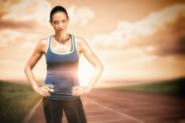 Sportvrouw poseren tegen atletiekbaan — Stockfoto