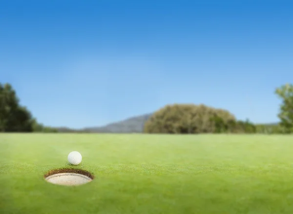 Bola de golfe na borda do buraco — Fotografia de Stock