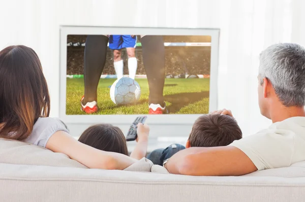 Famille assise sur le canapé regardant la télévision — Photo