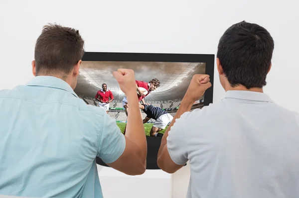 Två glada fotboll fläktar tittar på tv — Stockfoto