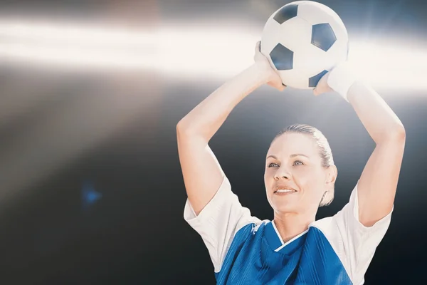Kvinnan fotbollspelare håller en boll — Stockfoto