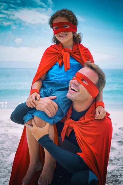 Père en costume de super-héros portant fils — Photo