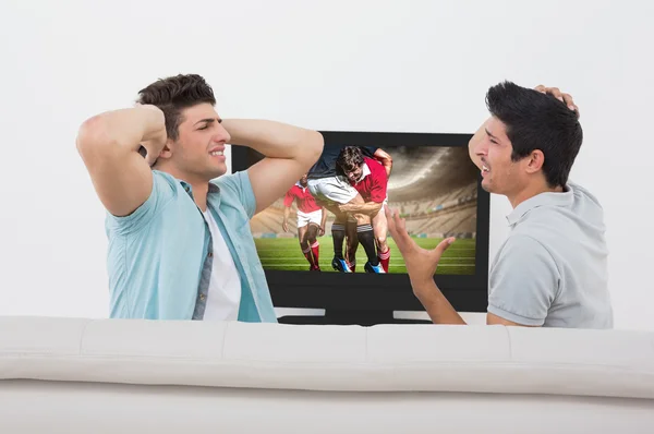 Besviken fotbollsfans tittar på tv — Stockfoto