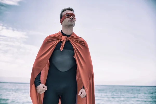 Man met superheld kostuum door zee — Stockfoto