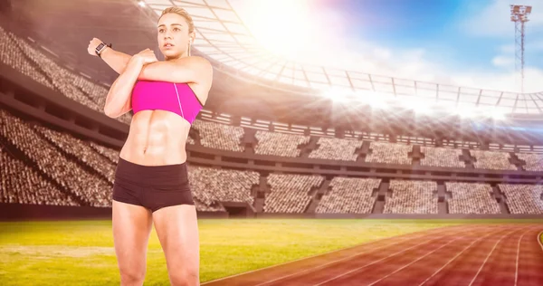 Atleta femenina estirando y escuchando música —  Fotos de Stock