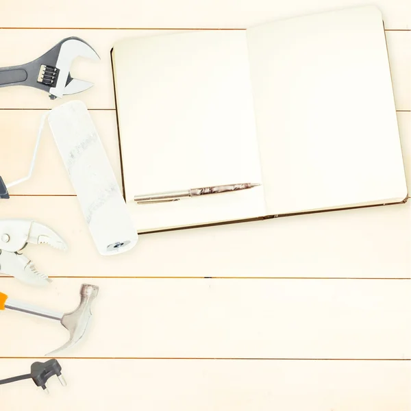 Strumenti e blocco note su sfondo di legno — Foto Stock