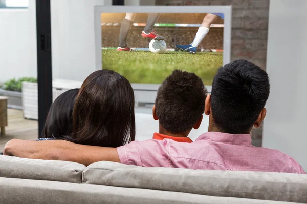 Familia viendo la televisión en el sofá — Foto de Stock