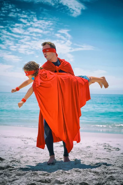 father in superhero costume lifting son