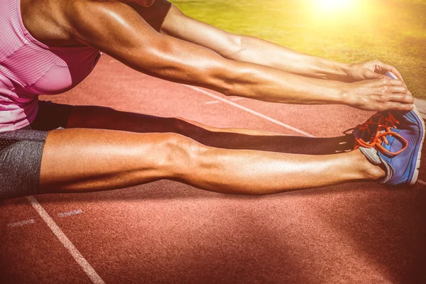 Sportvrouw haar spieren uit te rekken — Stockfoto