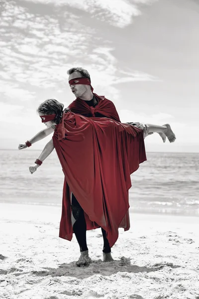 Père en costume de super-héros levant fils — Photo