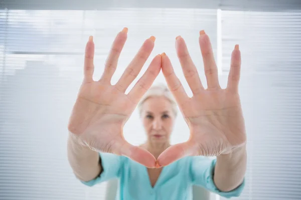 Femme âgée avec les mains sur le verre — Photo