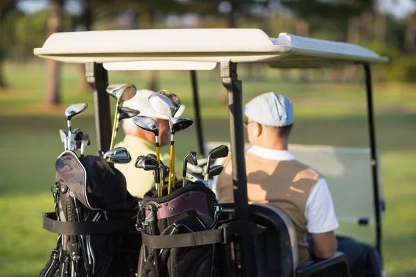 Amigos golfistas sentados en buggy de golf —  Fotos de Stock