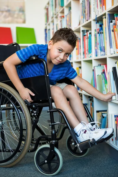 Handicapped boy searching books — Stock Photo, Image