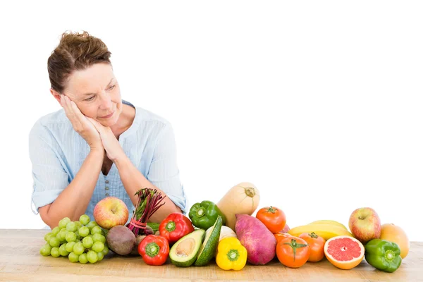 Mujer de pie junto a frutas y verduras —  Fotos de Stock