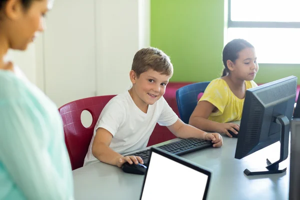 Jongen met klasgenoot en leraar met behulp van computers — Stockfoto