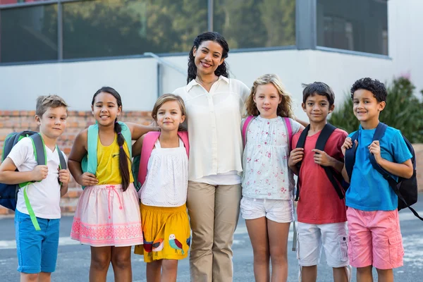 Lärare med barn står utanför skolan — Stockfoto