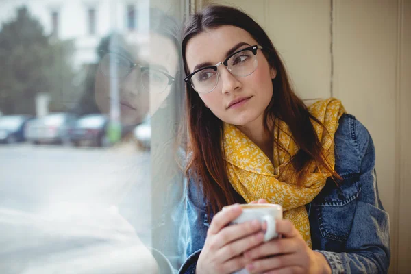 Mujer pensativa sentada con café — Foto de Stock