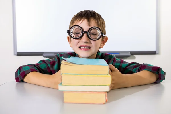 Niño feliz sosteniendo libros en la mesa —  Fotos de Stock