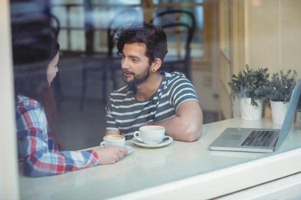 Pareja hablando mientras está sentado por la ventana — Foto de Stock