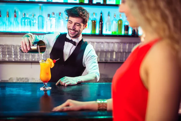 Bartender pouring cocktail in glass for customer — Stock Photo, Image